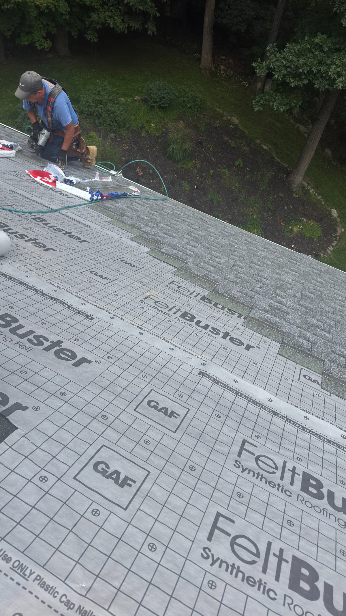 GAF FeltBuster synthetic underlayment being installed over a stripped roof deck on a North Jersey home