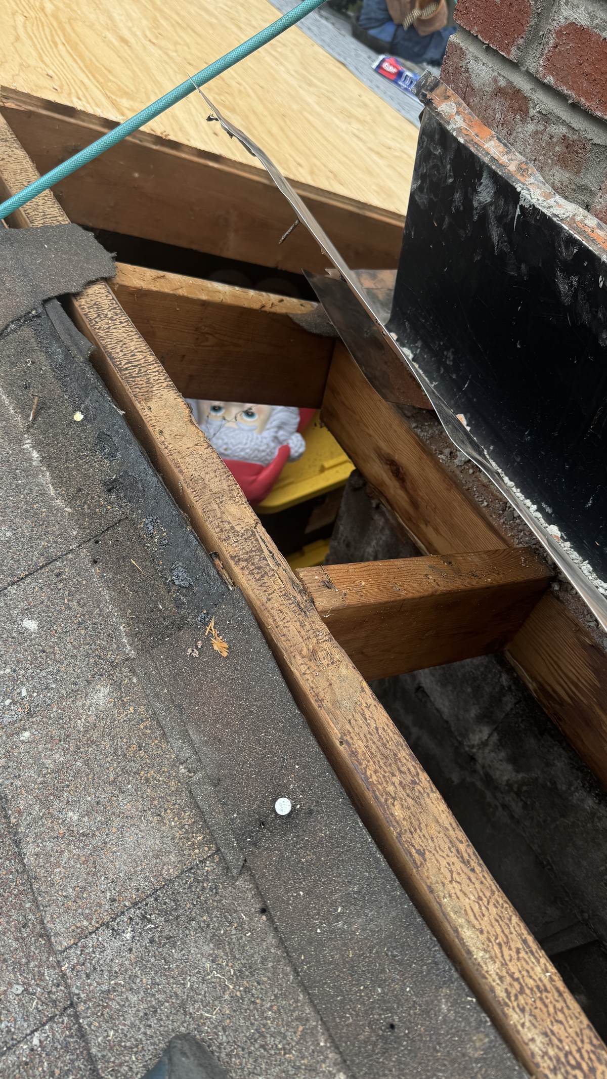 Open roof deck beside a chimney showing rotted sheathing and failed flashing in North Jersey