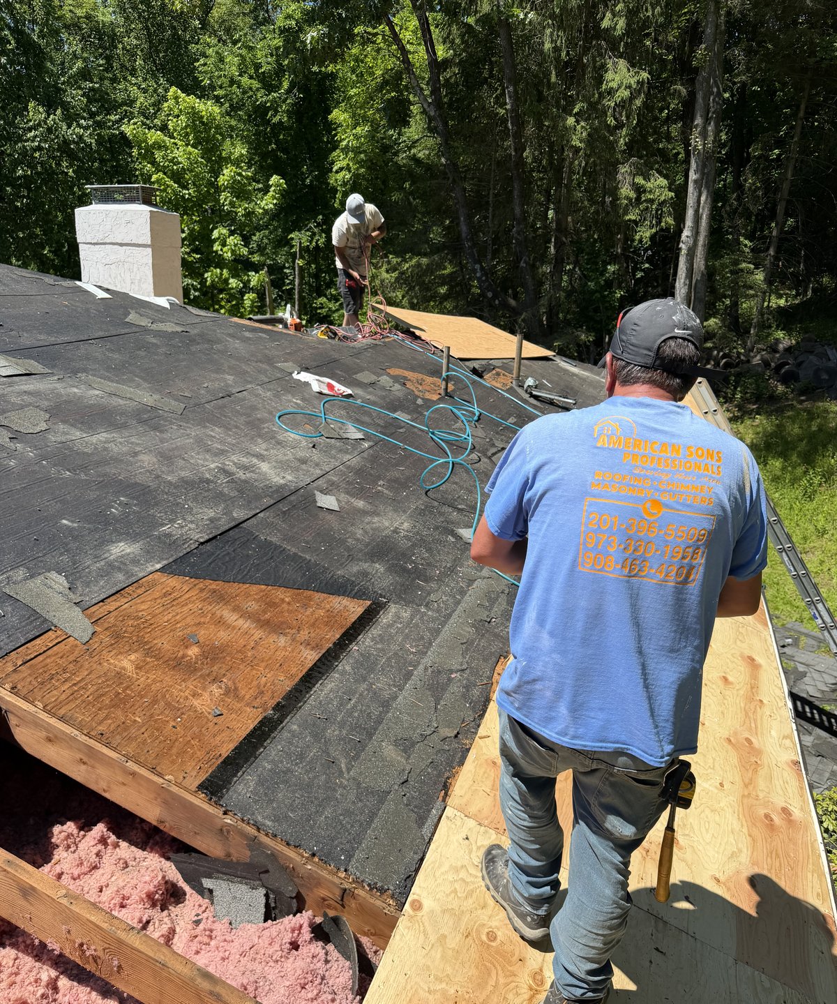 American Sons crew tearing off and re-decking a roof on a wooded property in Chester NJ