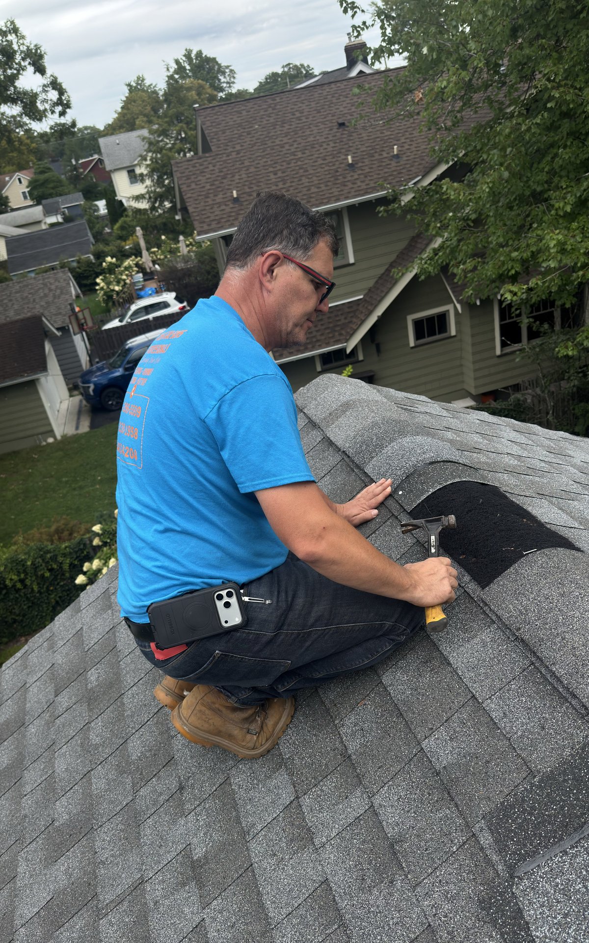 Sammy hand-nailing a ridge cap shingle during a roof repair in Madison NJ